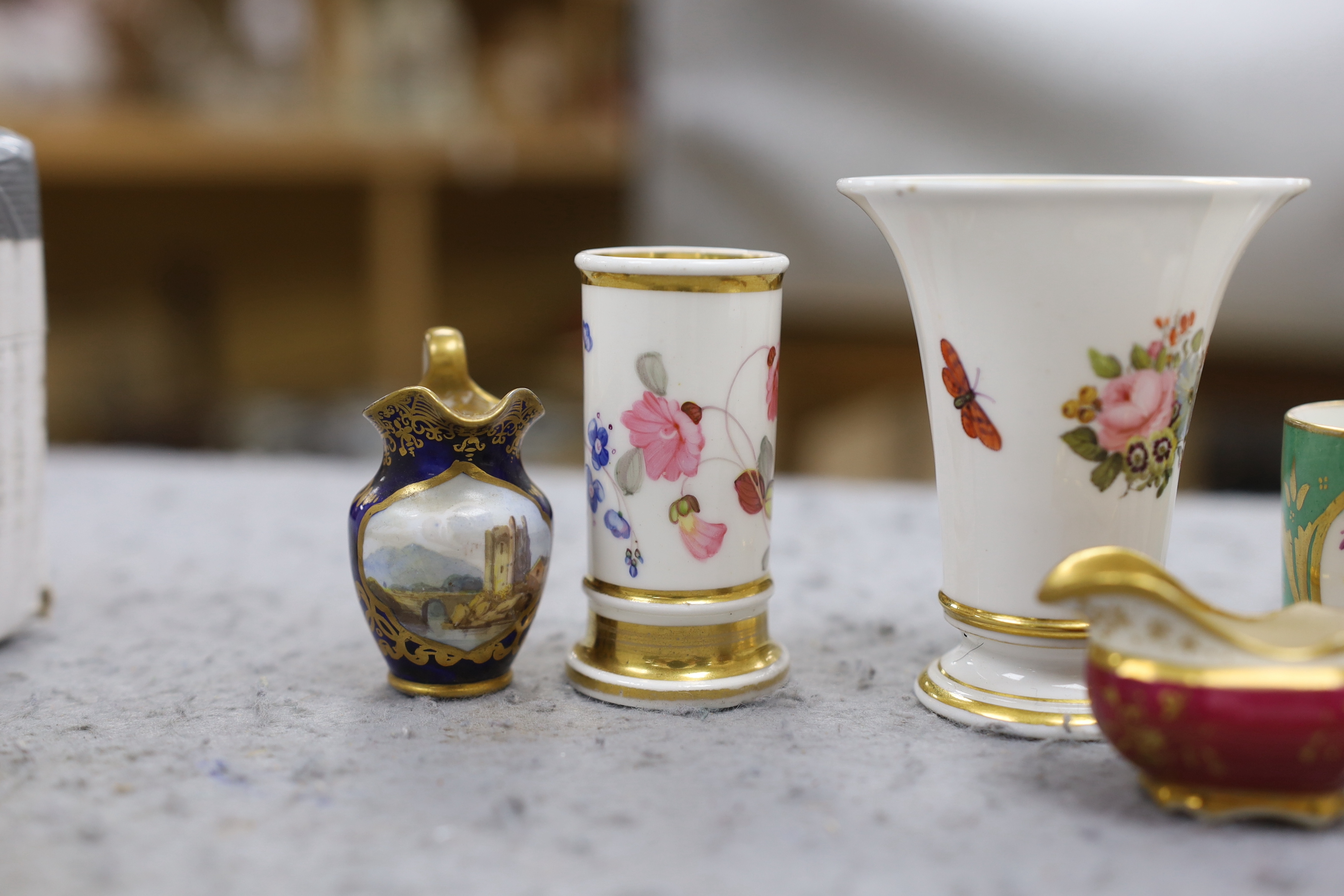 A 19th century Chamberlain Worcester miniature vase painted with flowers, script mark, a miniature jug with painted landscape on a blue ground, probably Chamberlain, an English jug and an English spill vase, an English g